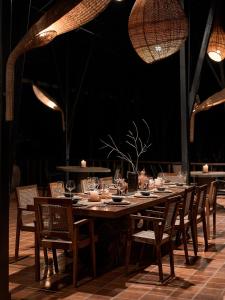 a long wooden table with chairs and lights at Tipai Wildlife Luxuries in Pahāpal
