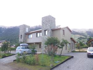 una casa con un coche aparcado delante de ella en Departamento Cerro Catedral en San Carlos de Bariloche