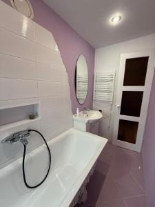 a bathroom with a white tub and a sink at Piejūras laivinieks in Liepāja +4 photos