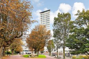 Una calle arbolada con un edificio alto al fondo en BizStay Toren van Oud, en La Haya