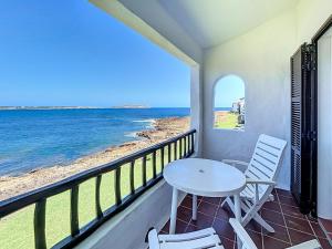 un balcone con tavolo e sedie e l'oceano di P98 - Bonito apartamento sobre el mar a Fornells
