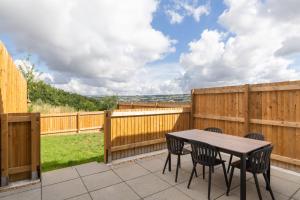 a patio with a wooden fence and a table and chairs at Newly Refurbished Home Short Drive to Bath Centre in Bath