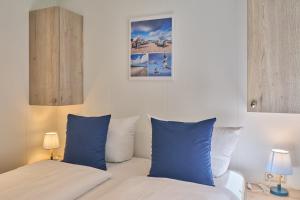 En eller flere senge i et værelse på Ostseecamp Ferienhaus Dünenglück