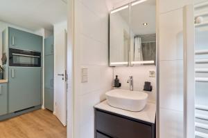 a white bathroom with a sink and a mirror at Ostseecamp Salt & Sea in Scharbeutz +25 photos
