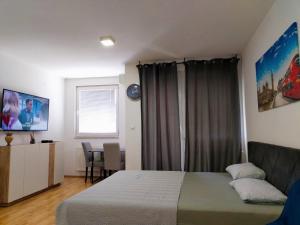 a bedroom with a bed and a table with chairs at Apartman Lanass Doboj in Doboj