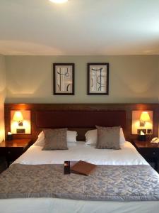 a bedroom with a large bed with two lamps at The Plough Inn & Restaurant in Congleton