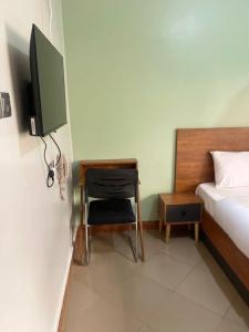 a bedroom with a desk and a bed and a television at Astro Motel in Nalakonge
