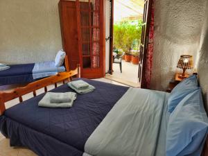 a bedroom with two beds and a door to a patio at Akrata Golden Beach House in Aíyira
