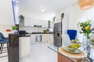 a kitchen with white cabinets and a table with flowers on it at 3BR Villa with Pool, Rooftop, and BBQ - Gated Area in Punta Cana