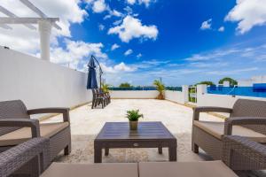 a patio with chairs and a table on a roof at 3BR Villa with Pool, Rooftop, and BBQ - Gated Area in Punta Cana