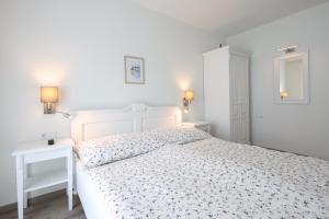a white bedroom with a white bed and a desk at Angele Pihenőház in Balatonszárszó