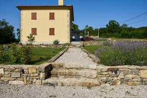 a stone retaining wall in front of a building at Villa Telma in Kostrčani - Haus für 8-10 Personen in Kostrčani