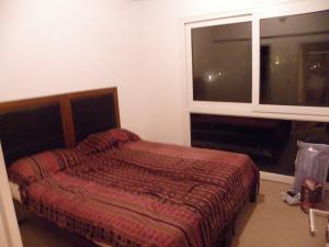 1 dormitorio con cama y ventana en Departamento Cerro Catedral en San Carlos de Bariloche