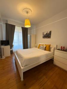 Un dormitorio con una gran cama blanca en una habitación. en Pensión Matilde, en Bilbao