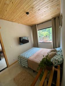 a small bedroom with a bed and a window at Raízes da Serra , Refúgio Beira-Rio no Baixo Sana in Córrego da Luz