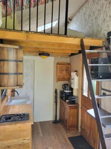 a kitchen with a staircase in a tiny house at Tiny House La Chevêchette in Besson