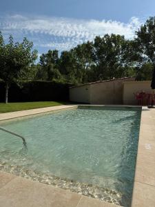 a swimming pool with blue water in a yard at Camping Bungalow el Llac de Banyoles in Porqueres
