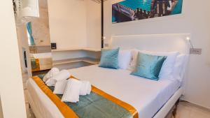 a small room with a bed with blue pillows at Suite Sirmione Studio - Italian Homing in Sirmione