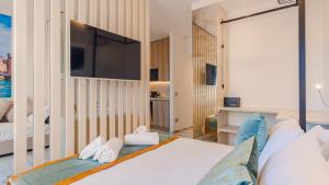 a bedroom with a bed and a tv on a wall at Suite Sirmione Studio - Italian Homing in Sirmione +3 photos