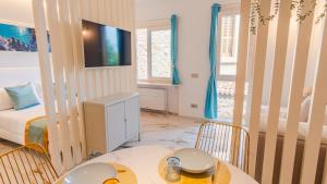 a room with a bed and a table and chairs at Suite Sirmione Studio - Italian Homing in Sirmione