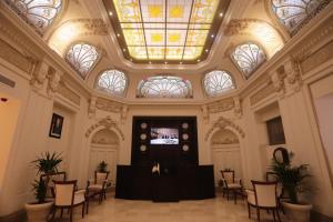 a lobby with a skylight and a table and chairs at Grand Hotel Oran in Oran