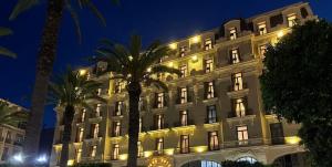 a lit up building with palm trees in front of it at Grand Hotel Oran in Oran