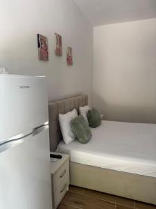 a small bedroom with a bed and a refrigerator at Doris Apartments in Himare