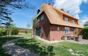 una casa con tetto di paglia e patio di Dünenzauber a List