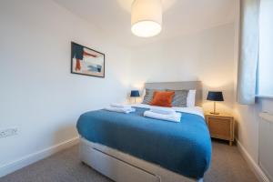a bedroom with a blue bed with towels on it at Atlanta's Residence by Tŷ SA in Newport