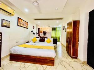 a bedroom with a large bed with yellow pillows at Hotel Hauz Khas Inn Near Hauz Khas Fort and Deer Park in New Delhi +95 photos