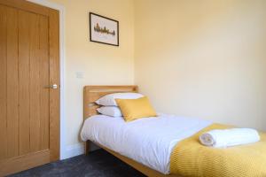 a bedroom with a bed and a wooden door at Beechwood House by Tŷ SA - ICC & Celtic Manor in Newport
