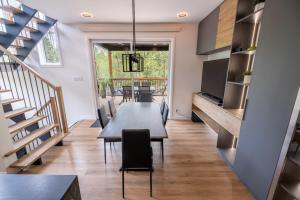 ein Esszimmer mit einem Tisch, Stühlen und einer Treppe in der Unterkunft Nature Comfort & SPA - Chalet Moderno in Sainte Brigitte de Laval + 38 Fotos