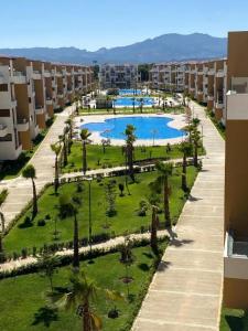 カボ・ネグロにあるAppartement haut standing mirador golf 3のプールとヤシの木があるリゾートの空中ビュー