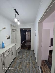 a kitchen with white walls and wooden floors and a hallway at David & Matei Residence in Jurilovca +43 photos