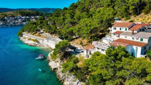 une maison sur une colline à côté de l'eau dans l'établissement Lučica, Luxury Rooms By the Sea, à Pučišća
