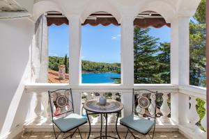 a view from the balcony of a house with a table and chairs at APARTMENTS JADRANKa in Omišalj