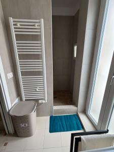 een badkamer met een douche, een toilet en een blauwe mat bij Maison Remì in Castellana Grotte