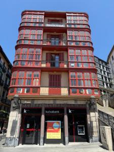 un edificio alto de ladrillo rojo con ventana en Pensión Matilde, en Bilbao 12 fotos más