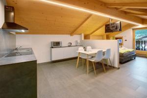 una cucina e una sala da pranzo con tavolo e sedie di Chalet da Maria a Livigno