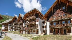 eine Gruppe von Holzgebäuden mit Balkonen darauf in der Unterkunft Les fermes de Saint Sorlin H 105 - 2P6 in Saint-Sorlin-dʼArves