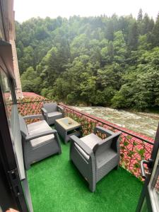 a balcony with chairs and a table and grass at İngolaSuit in Çamlıhemşin