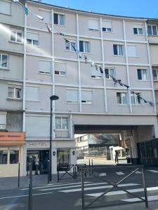 a large white building with flags hanging from it at Le Faidherbe Hotel Coeur de ville in Boulogne-sur-Mer
