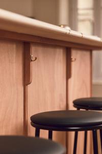 ラ・ロシェルにあるオテル アンリ IVの木製のカウンタートップの下に置かれた2つのスツール