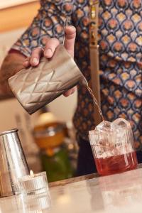 ラ・ロシェルにあるオテル アンリ IVの人がグラスに入った飲み物を持ち上げている +105枚の写真