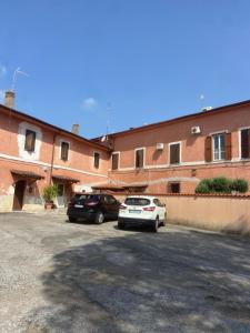 two cars parked in a parking lot in front of a building at La Casa del Borgo Antico in Campoverde
