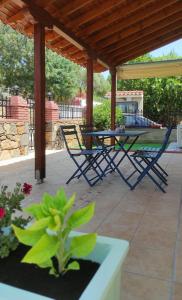 a patio with a table and chairs under a roof at Epiphany Moudros Apartment in Moúdhros
