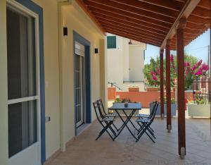 a patio with chairs and a table on a balcony at Epiphany Moudros Apartment in Moúdhros
