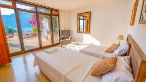 Un dormitorio con dos camas y una gran ventana. en VİLLA OZ, en Kas