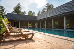 a pair of chairs sitting on a patio next to a swimming pool at JK Dwór Grabowszczyzna in Huszcza