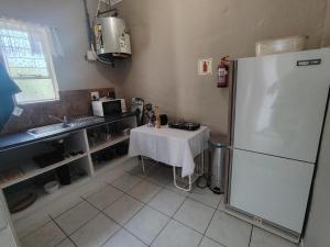 eine Küche mit Tisch und Kühlschrank in der Unterkunft Cornelia Place in Sunridge Park